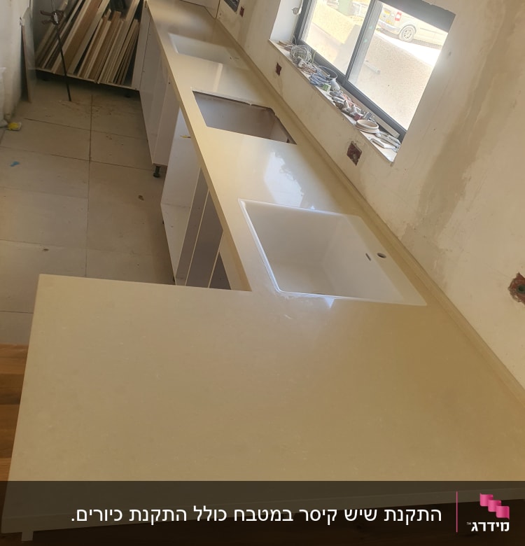משטח שיש בהיר עם כיור מובנה במטבח